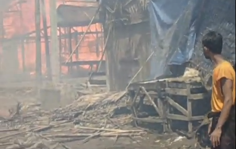 A man watches Rohingya homes burn in Burma/Myanmar.