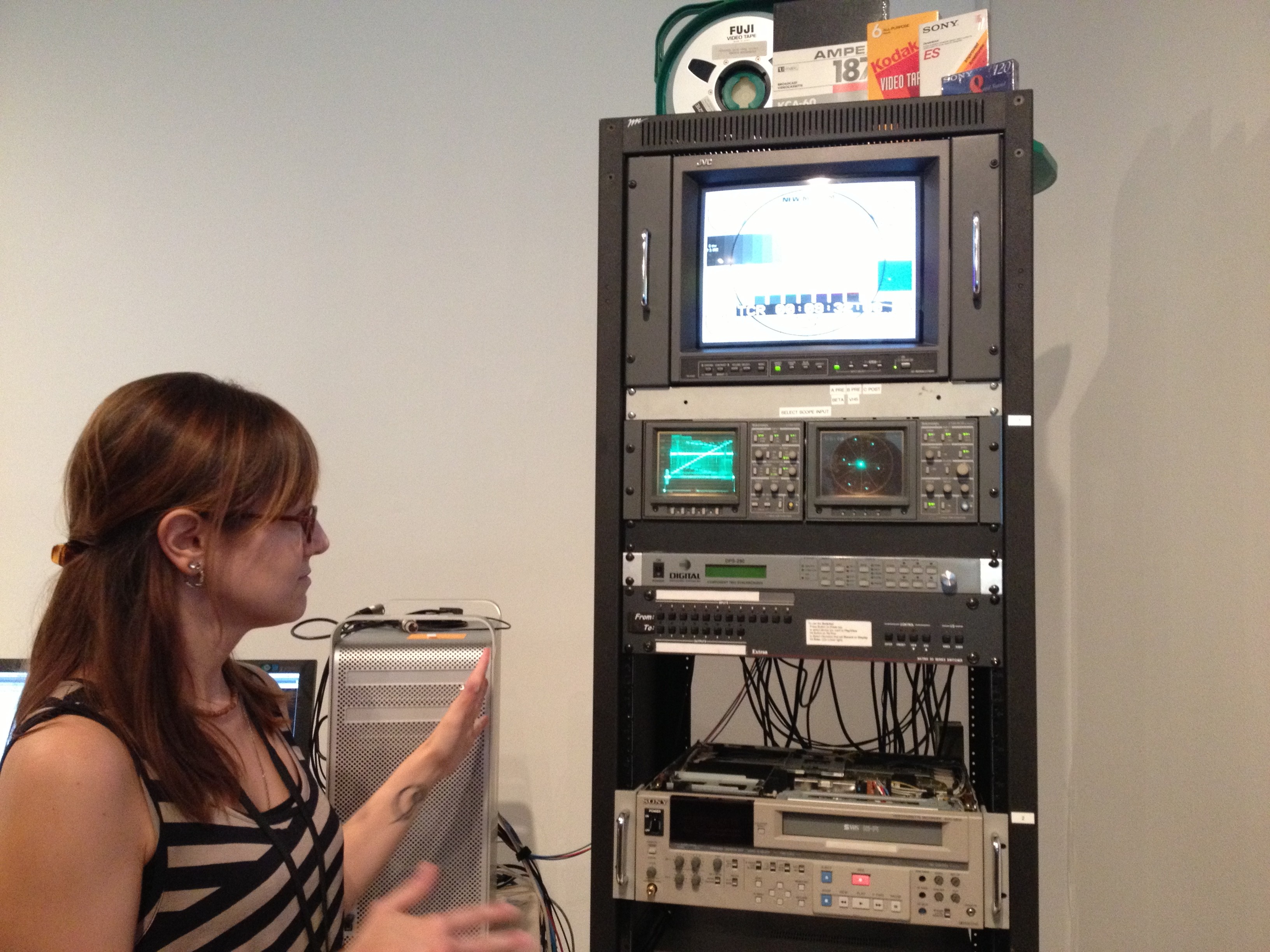 Kristin explains a basic transfer station setup, which includes playback decks, time-base corrector, a-d converter, waveform monitor, vectorscope, video monitor, capture card, and a computer with editing software.